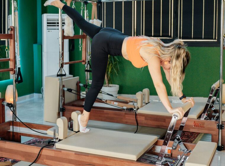 Mujer realizando un ejercicio en una máquina de Pilates Reformer